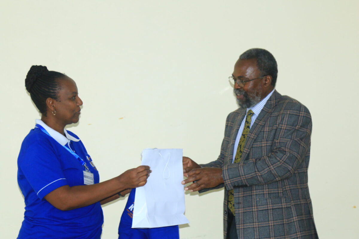 Dr. Catherine Amulundu gifting Prof. Mailutha after gracing the occasion with his Keynote Speech. PHOTO/Kisii University Media.
