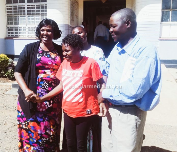 Celebrating Awuor Lavendar Awuor (center) shaking hands with Mercy Juma, principal Uasin Gishu High School, as her father, Pius Ouru, holds her in celebrating her A grade in 2022 KCSE results. PHOTO/Edmond Kipngeno, The Scholar Media Africa.