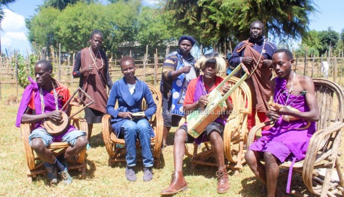 Kesses Family The Kesses family donning their traditional attire pose for a photo with Janet Kiriswo (second left). The family is made up of both traditional and gospel musicians with deep excellence in music. PHOTO/Janet Kiriswo, The Scholar Media Africa.