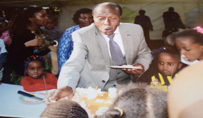 Professor David Ngugi, shares a piece of cake with his grandchildren on his 80th Birthday celebration. PHOTO/Courtesy.