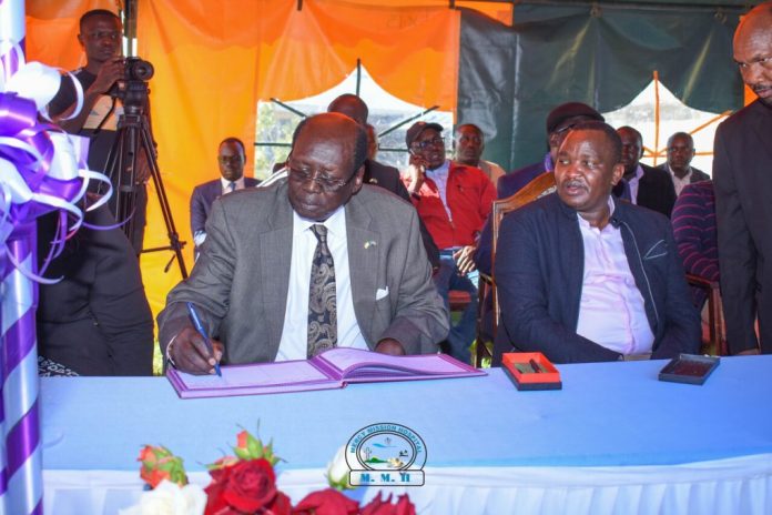 Barnabas Benjamin, Minister for Presidential Affairs of the Republic of South Sudan, signing the visitors book after leading a delegation to visit the health facility for rescuing President Salva Kiir's life three decades ago. Beside him is Felix Kimwok Baringo County Deputy Governor. PHOTO/Mercy Mission Hospital (MMH).