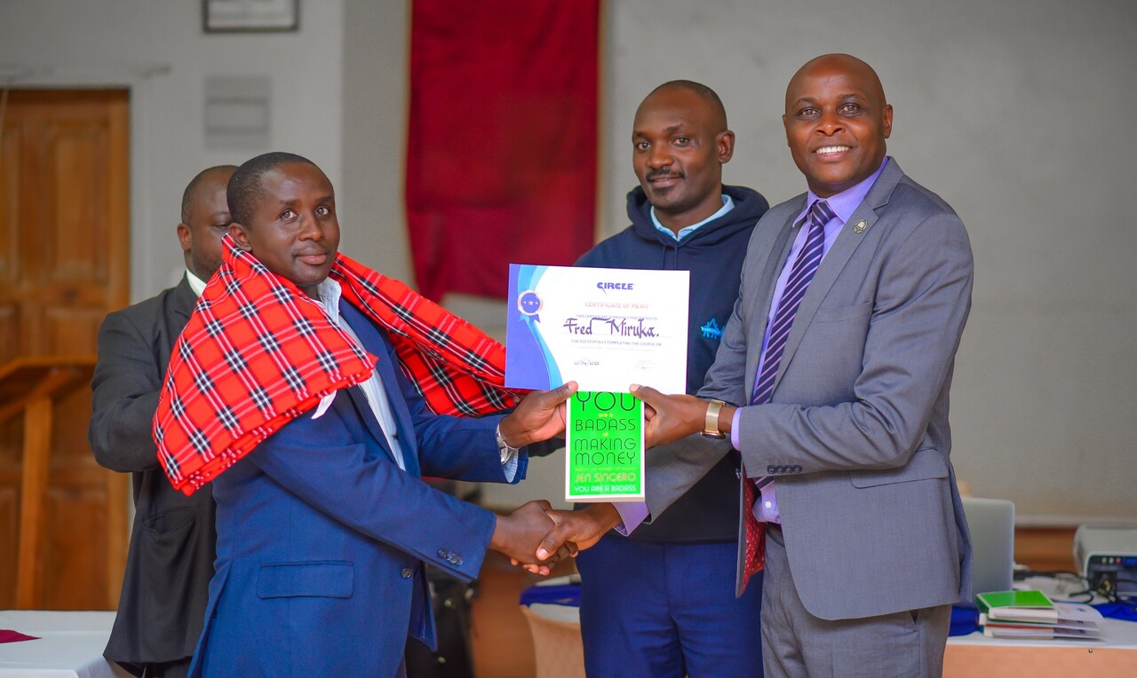Dr. Okibo awarding a certificate and other giftings to Fred Miruka (left), one one of the managers, as Ronald Manyasia, Operations Manager Wakenya Pamoja Sacco, looks on. PHOTO/Arise Circle. 