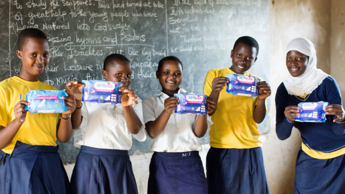 School-girls holding sanitary pads in a classroom. As the world celebrates World Menstrual Hygiene Day on May 28, 2023, statistics show that in Africa, 1 in every 3 women cannot afford sanitary products. Destigmatizing menstrual health and providing girls and women with menstrual products is timely and vital. PHOTO/Courtesy.
