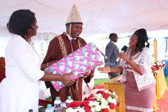 Prof. John Akama and wife, Dr. Mallion Onyambu, receive a gift from Vicky Nyaboke (right) during a farewell party to mark the end of Prof. Akama's tenure as Vice Chancellor, Kisii University. PHOTO/Josephat Nehemiah, Scholar Media Africa.